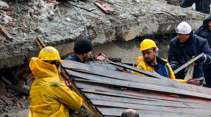 Helfer suchen nach Verletzten unter den Trümmern.